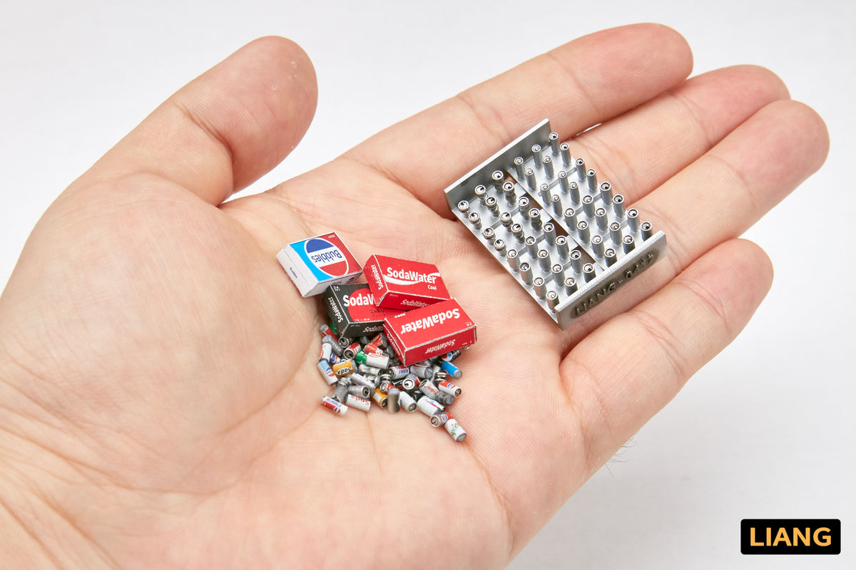 Liang Model LIANG-0411 1/35 soda cans and cardboard boxes shown in a hand to demonstrate the extremely small scale and fine 3D-printed detail.