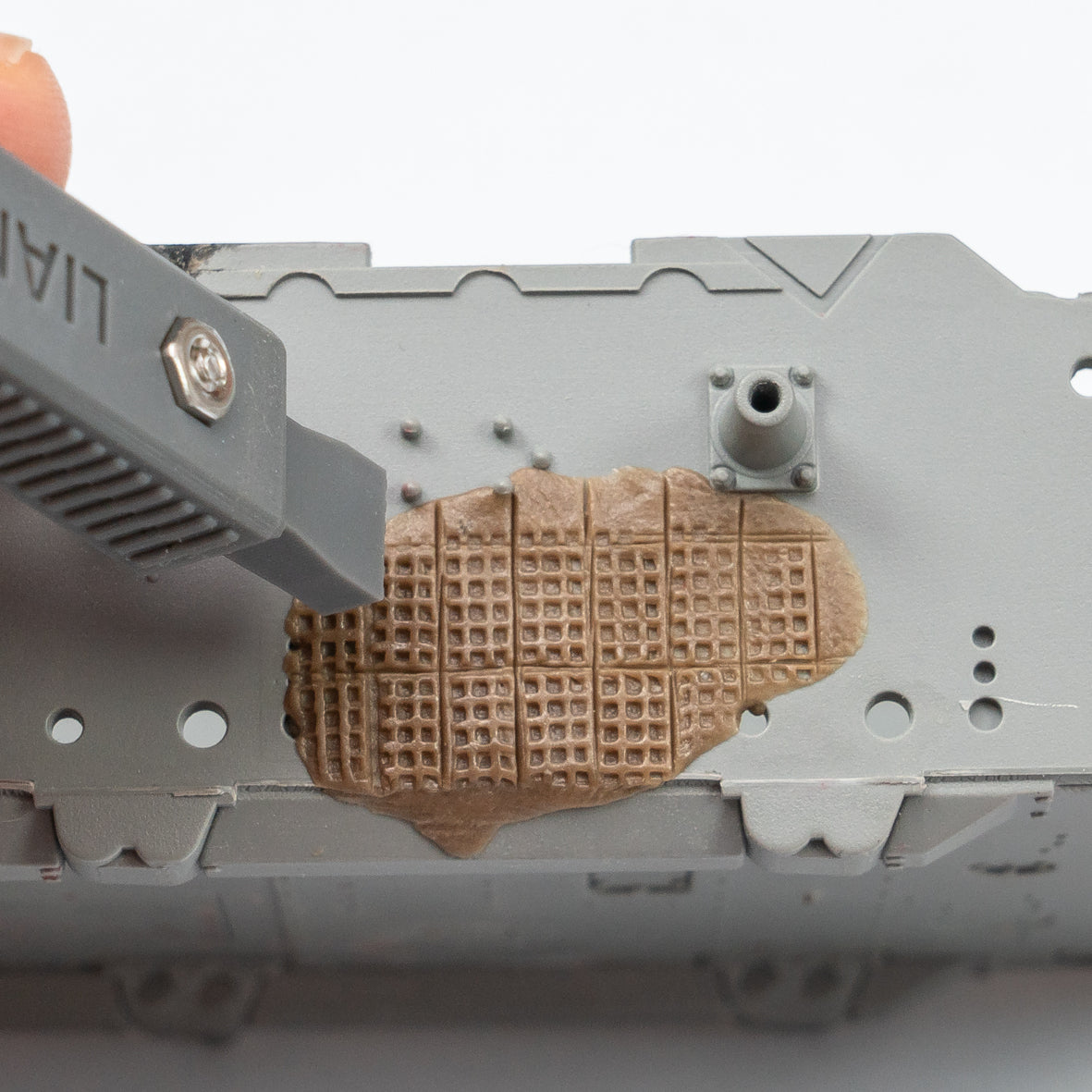 Liang Model LIANG-0229B Zimmerit Coat Upgrade Tool creating a precise square-pattern Zimmerit texture in modeling putty on a German tank model.