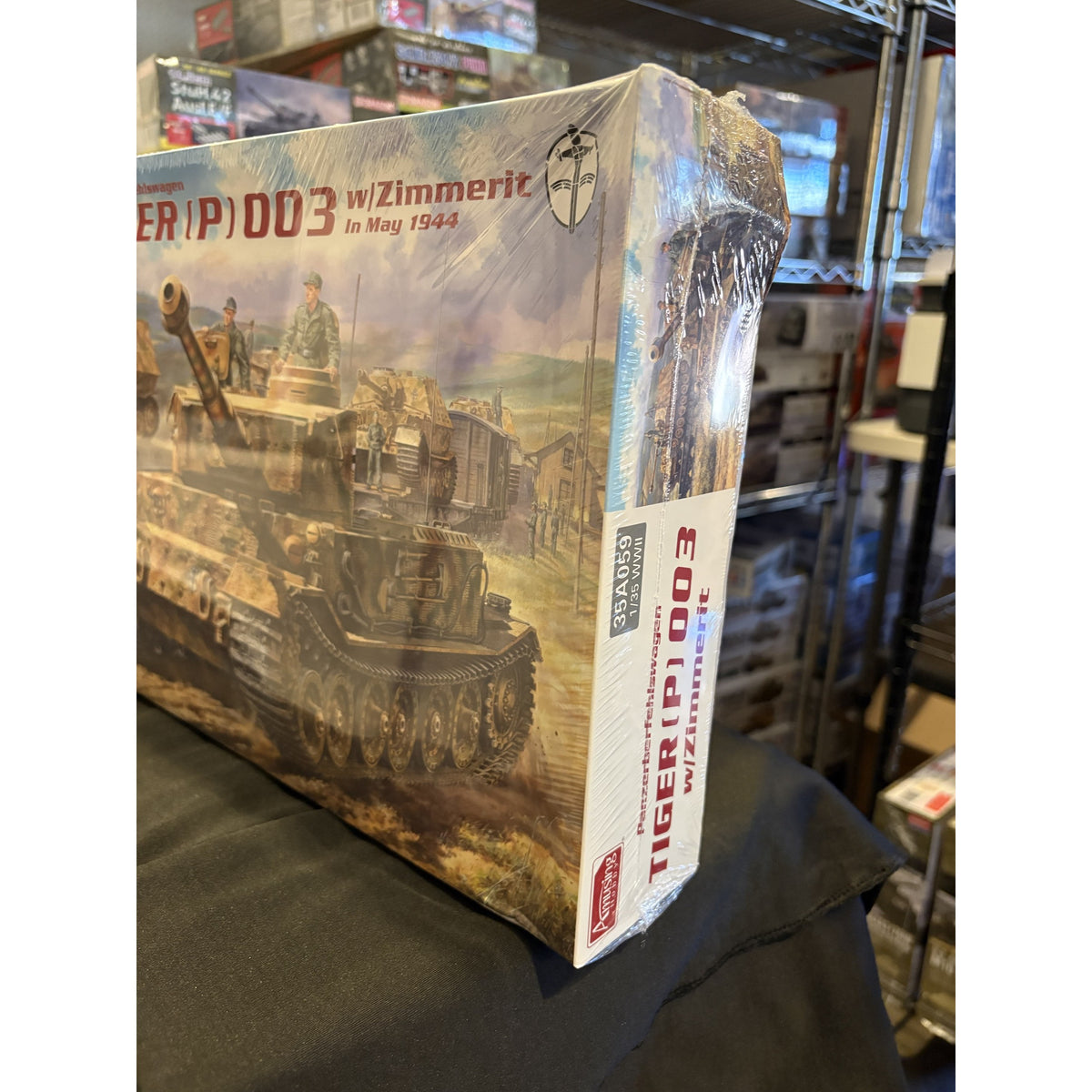 Amusing Hobby 35A059 Tiger (P) 003 with Zimmerit 1/35 model kit box showing a crushed corner and creased end panel, still factory sealed in shrink wrap