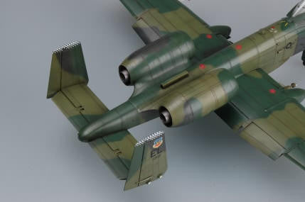 Model of a military aircraft with green and brown camouflage on a gray background