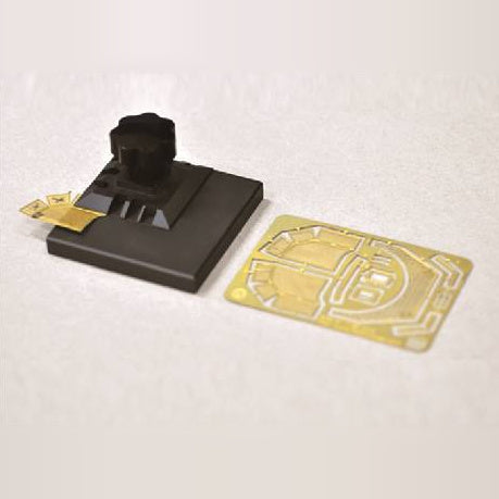 Master Tools 09933 small photo-etched parts bender folding a brass photo-etch part, next to a photo-etch fret.