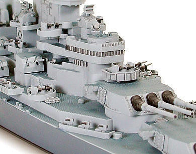 Model of a battleship with detailed superstructure and gun turrets on a white background