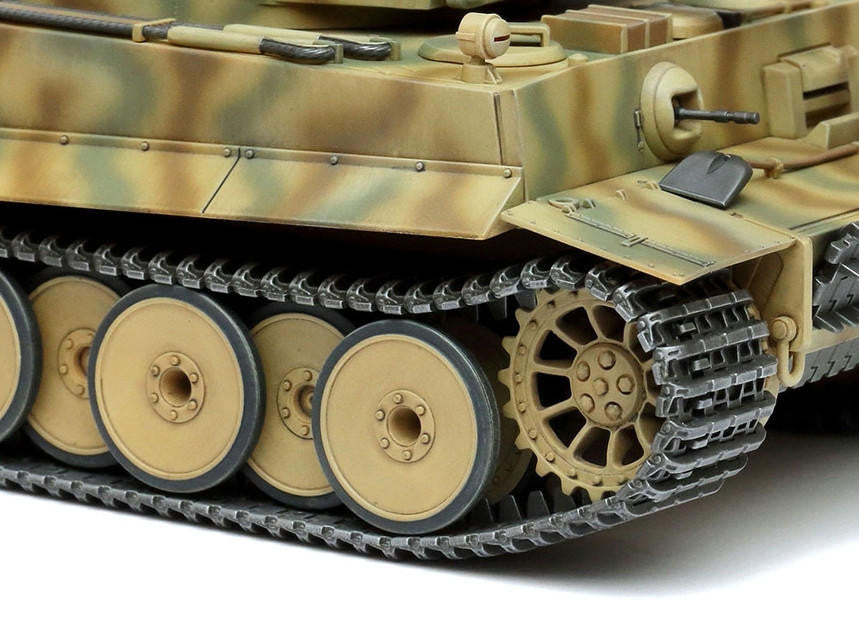 Close-up of a model tank with detailed tracks and camouflage pattern on a white background